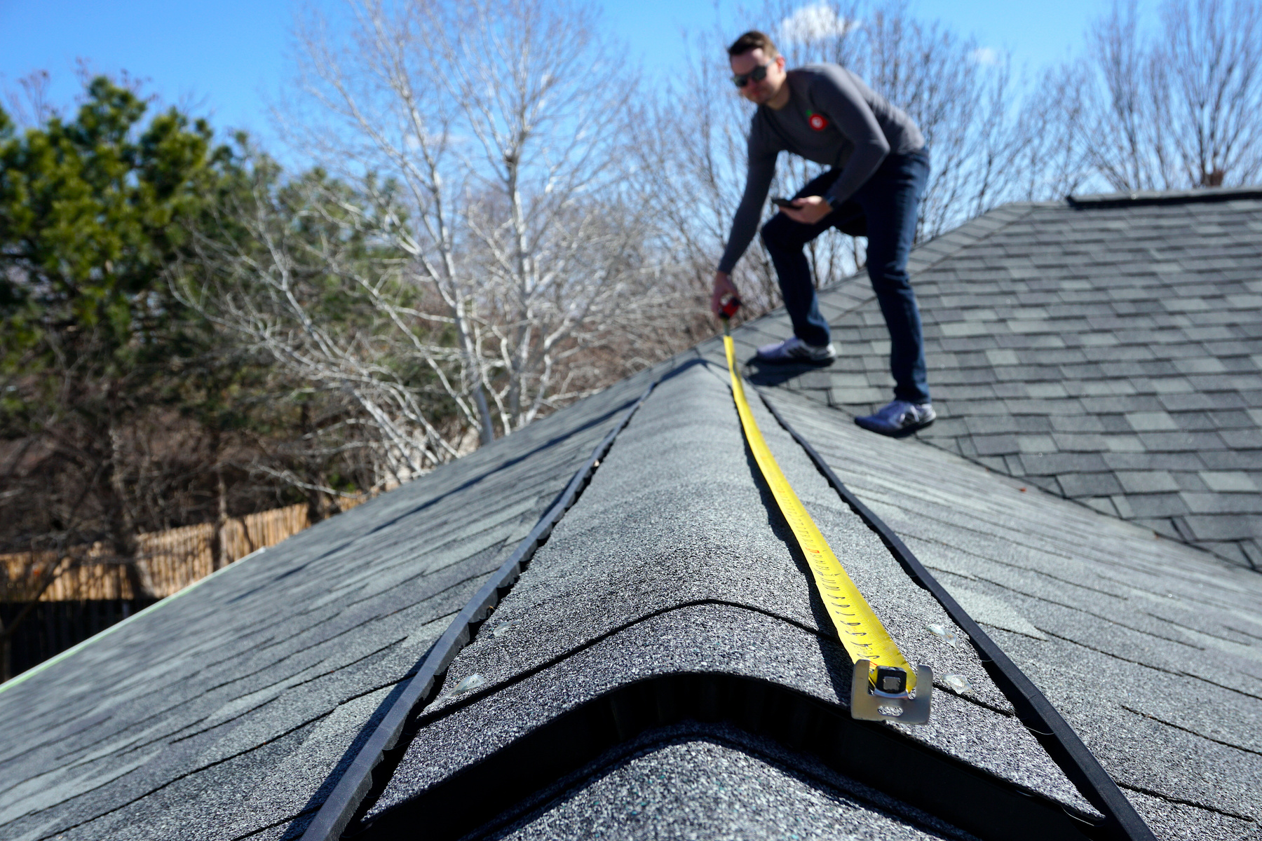 A Man Measuring the Roof